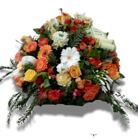 coussin funéraire rond avec fleurs orange, rouges et blanches, feuillage vert